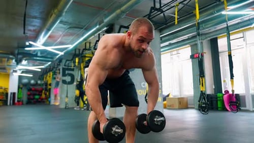 Bald Bodybuilder Lifting Dumbbell In The Gym