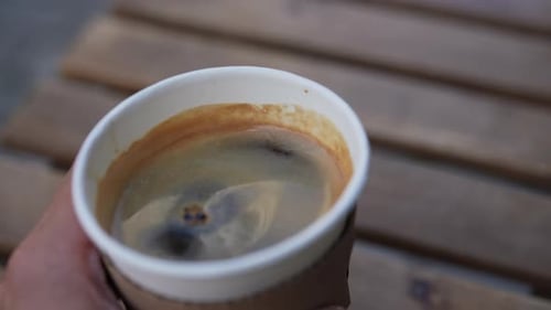 Fresh Coffee Cup Held Over Wooden Surface