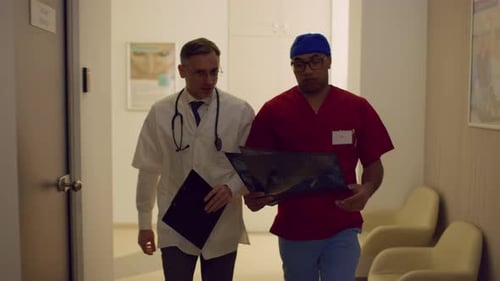Doctors Reviewing X-Ray in Hospital Corridor