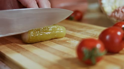 Close Up of Pickle Being Sliced on Board