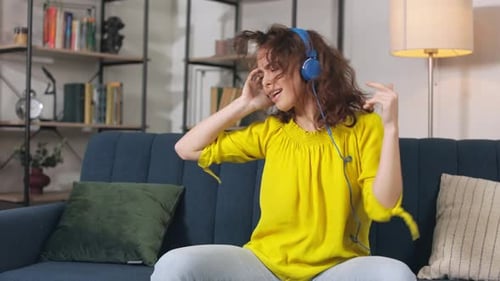 Woman Listening to Music and Dancing on Couch