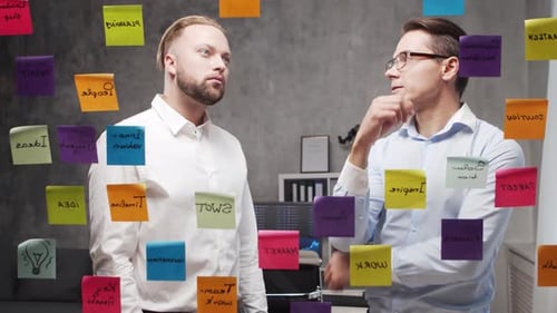 Team of Business People is Doing Brainstorm at a Meeting Using Stickers on the Glass Office Workers