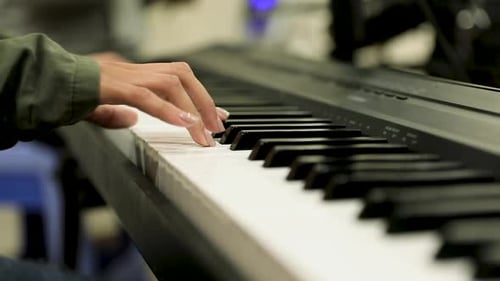 A girl playing the piano in the studio - close up