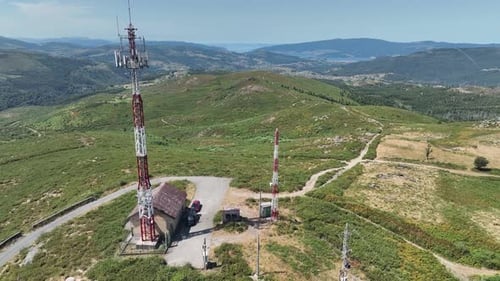 aerial view of telecommunications towers at hill top with the sea in the background