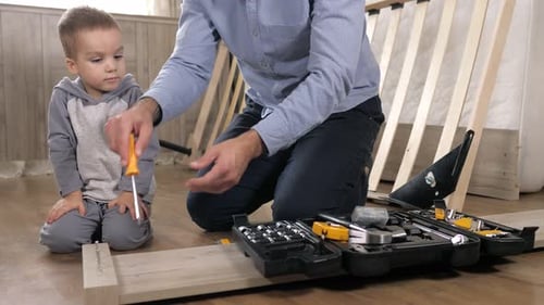 Child Helps Adult Assemble Furniture at Home