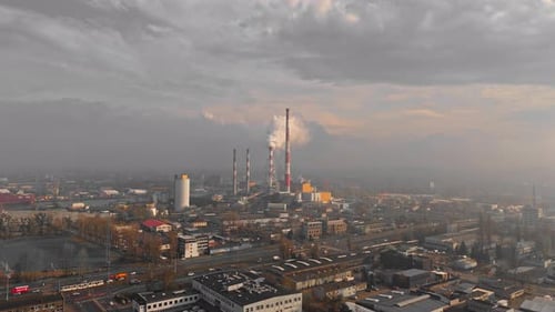 Air Pollution Concept Aerial Drone Video of a Factory Chimney in a City's Industrial Zone with Smoke