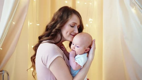 Loving Mother Gently Cradles Her Baby Indoors