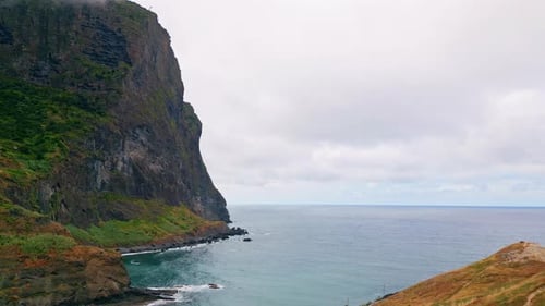 Tall Rock Standing Shoreline Aerial View Waves Crashing Stone Under Cloudy Sky