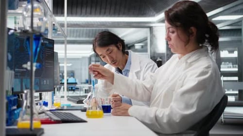 Directeur du laboratoire et stagiaire secouent la verrerie remplie d'une solution indicatrice verte