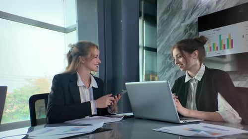 Business meeting in modern office between two professionals discussing documents