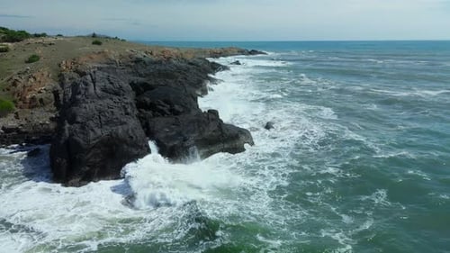 Aerial Slow Motion View of Waves Breaking Against Rocks on a Rocky Coastline Large Ocean Beautiful