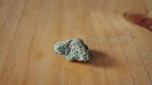 Dry CBD Medical Cannabis Weed Buds Outside of a Jar on Table Macro Closeup of Medical Marijuana