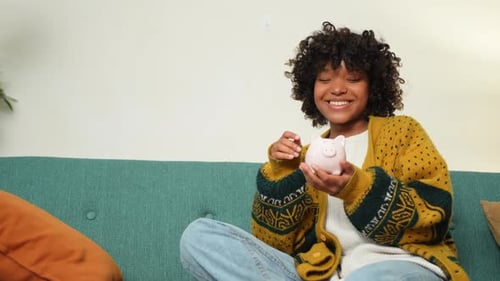 Saving Money Investment for Future African American Girl Holding Pink Piggy Bank and Putting Money