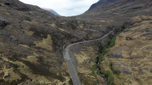 Aerial view of a valley in the Highlands with a road that winds through the m
