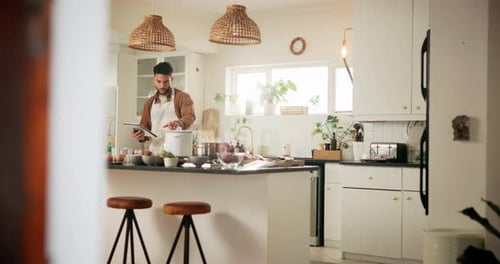 Man Using Tablet to Cook in Kitchen