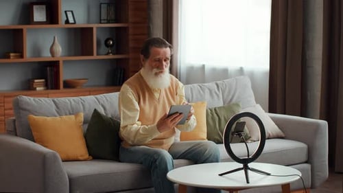 Senior Man Using Tablet Device on Couch at Home
