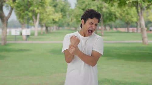 Sick Indian man having hand pain
