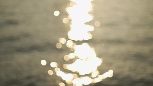 Blur bokeh effect of sunlight falling on a sea with waves during afternoon.
