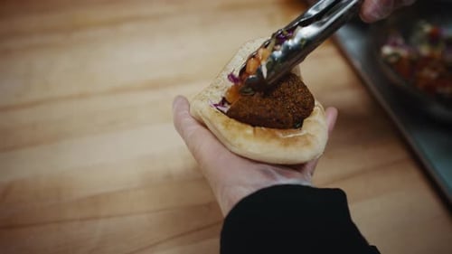 Filling Pita Bread Pocket with Falafel and Salad