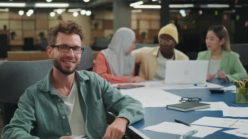 Portrait of a Creative European Businessman Sitting at a Table in the Office Team Leader