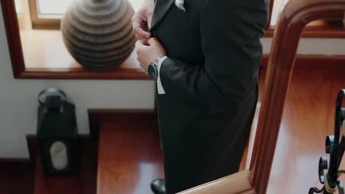 Groom Buttoning Suit Jacket on Wedding Day