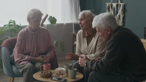 Seniors Talk Together in Living Room with Coffee