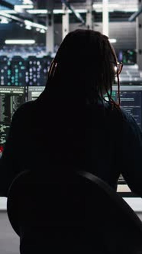 Programmer Coding at Multiple Monitors in Dark Room