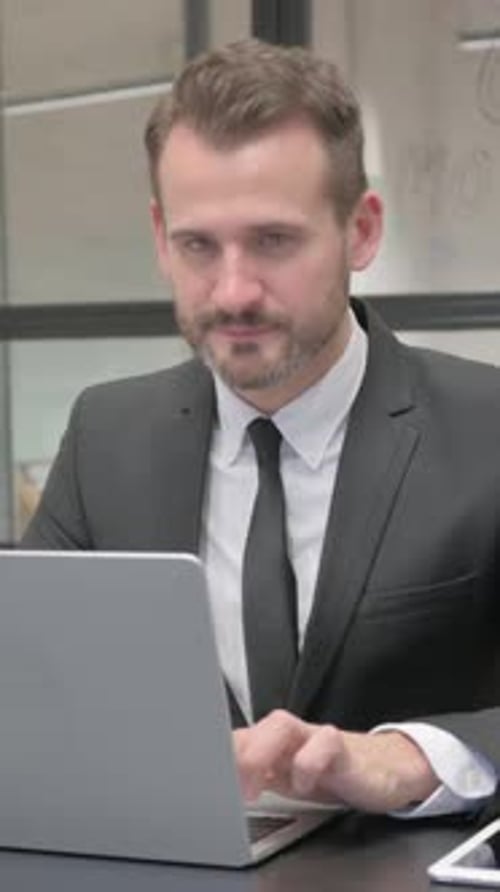 Businessman Working on Laptop Gives a Thumbs Up