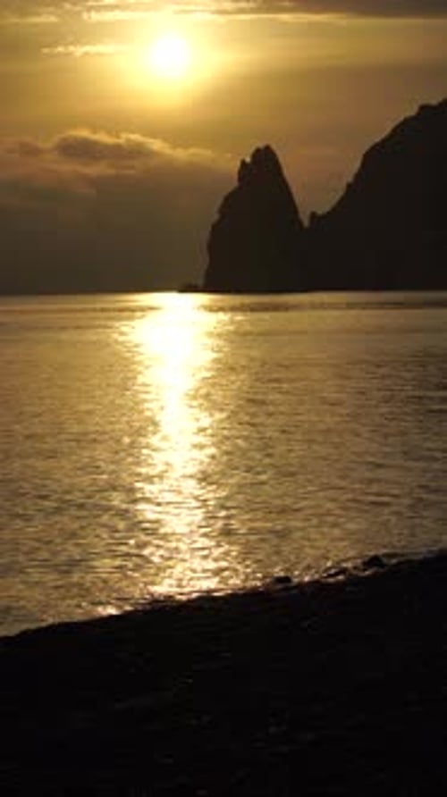 A Red Burning Sunset Over Sea with Rocky Volcanic Cliff Abstract Nature Summer Ocean Sea Background