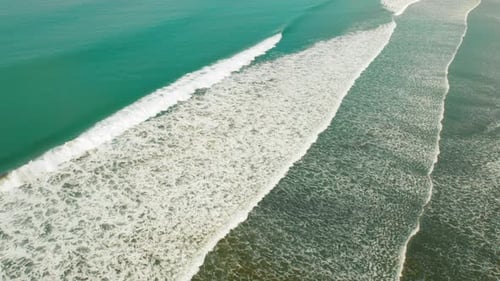 Pacific Ocean waves approaching shore in turquoise ocean under tropical sunlight