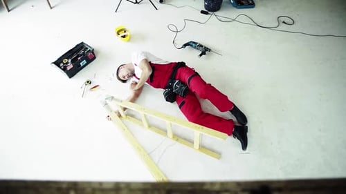 Construction site accident top view of injured man lying on floor after fall