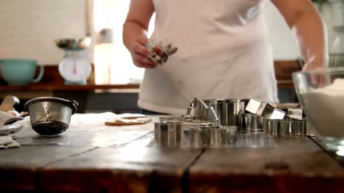 Woman Cuts Dough with Cookie Cutters in Kitchen
