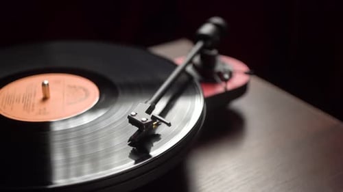 man starts a vintage vinyl player in a cozy room. close-up.