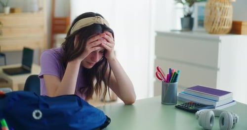 A Sad Young Student Breaks Down After Returning From School and Sits Sadly at Her Desk