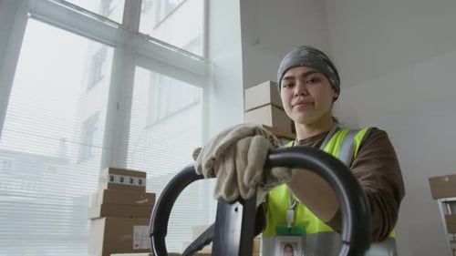 Retrato de ángulo bajo de una joven segura de sí misma con chaleco verde de alta visibilidad
