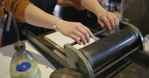 Woman Working on Printing Press in Workshop
