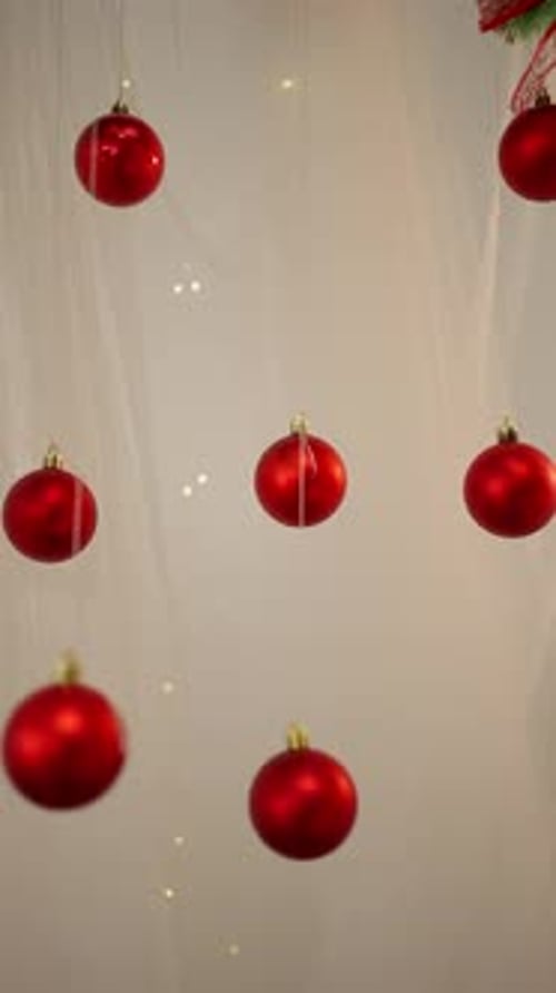 Festive Red Christmas Ornaments Swaying on White Background