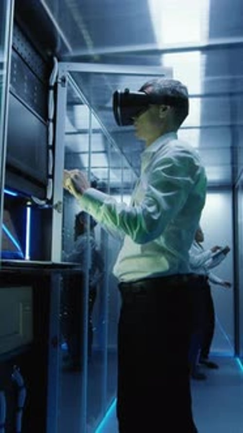 Technician Works in a Data Center Wearing a VR Headset