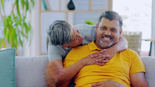 Conversation, hug and happy old couple kiss, talking and bonding on lounge sofa for romance