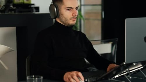 Man Working at Computer with Headphones On