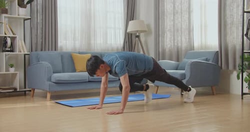 Fitness Asian Male Is Doing Mountain Climber Exercises In His Home