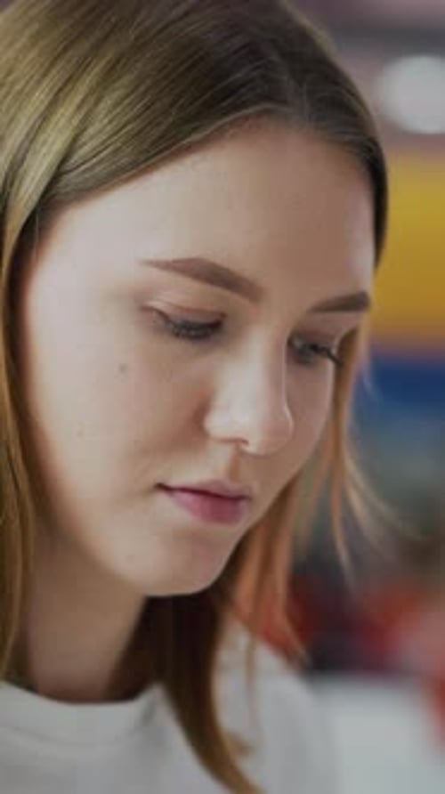 Closeup of Thoughtful Woman in Mall with Colorful Blurred Background