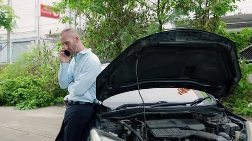 Caucasian male office worker using the phone to call insurance agent. Come to make warranty claim.