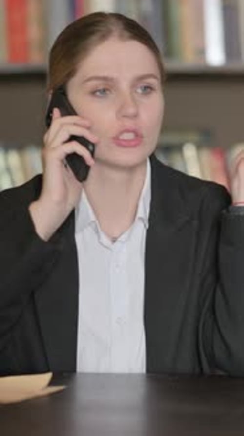 Upset FeLawyer Arguing on Phone in Office, vertical