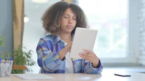 Cheerful Young African Woman using Tablet Computer