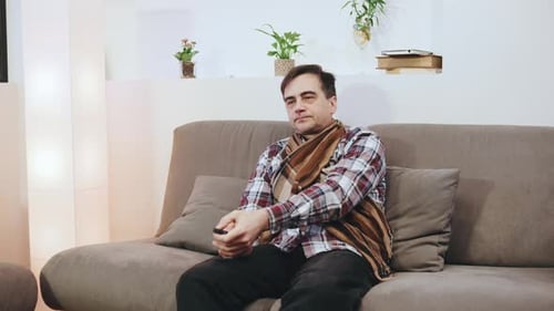 An Elderly Sick Man in a Scarf and a Plaid Shirt Tired Falls on the Pillows to Rest and Overcome the
