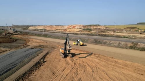 Excavator and Roller Working on Road Construction Clip