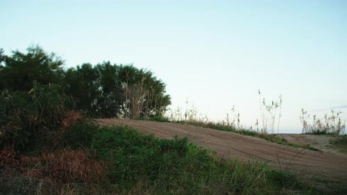 Motocross Racer Speeds Uphill on Dirt Track