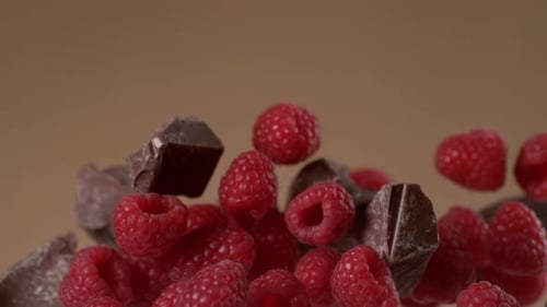 Chocolate chunks and raspberries floating in mid-air