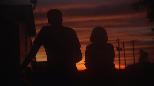Silhouetted Couple Enjoying Vibrant Sunset View